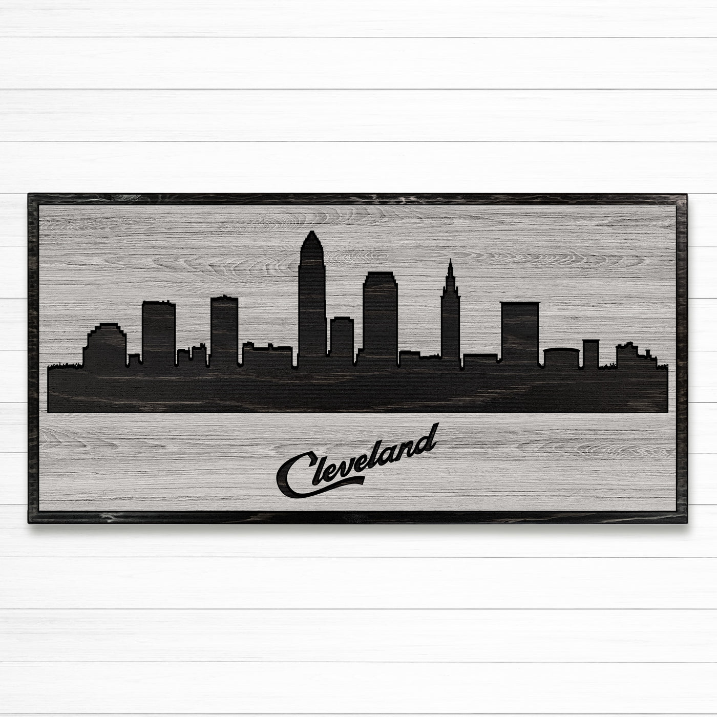 Carved wood wall art featuring the Cleveland, Ohio city skyline with detailed buildings and natural wood grain finish.