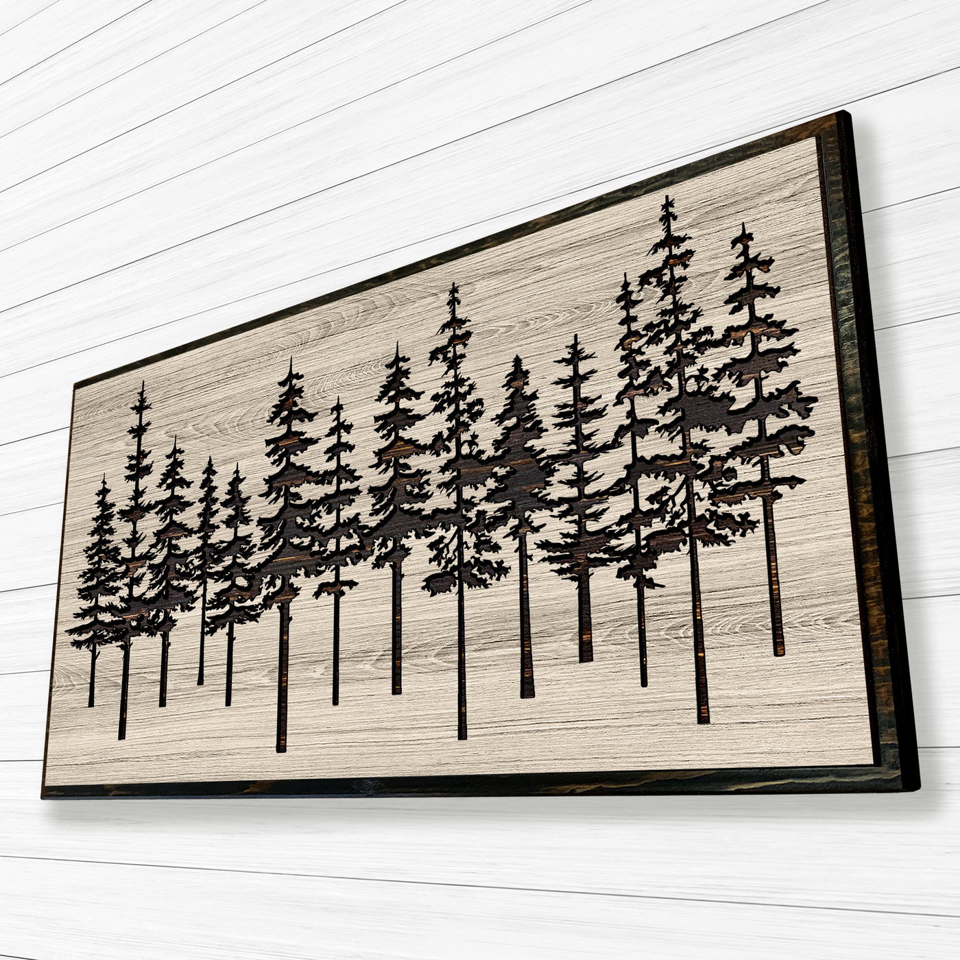 Pine tree forest wood wall art carved into solid wood. The stunning artwork features a carved pine tree scene nestled against a serene forest backdrop. That natural variations in the wood grain add a depth and character to the overall design, creating a warm and inviting atmosphere for any room.