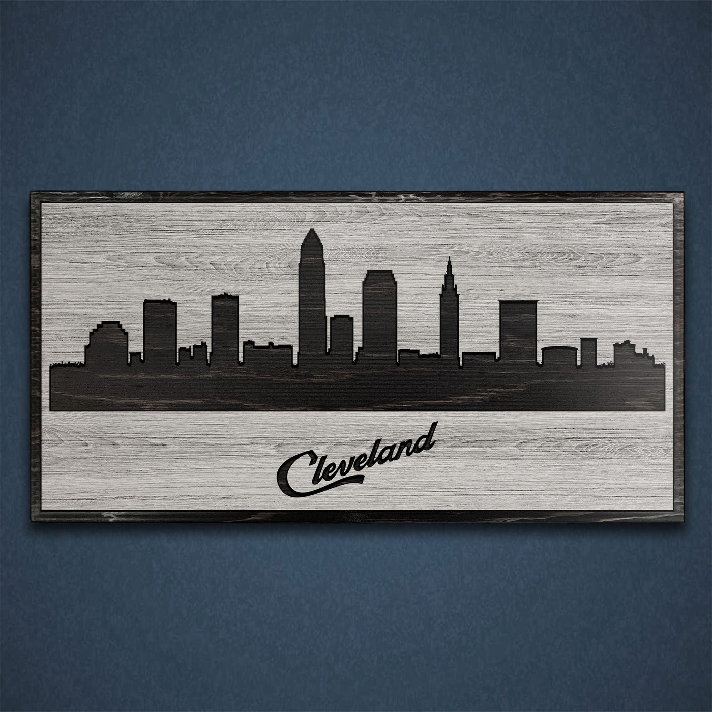 Carved wood wall art featuring the Cleveland, Ohio city skyline with detailed buildings and natural wood grain finish.